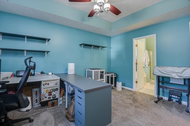 carpeted office featuring ceiling fan and a textured ceiling