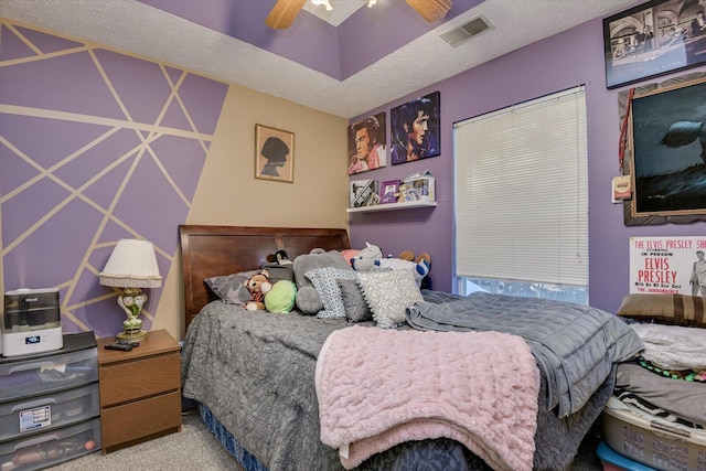 carpeted bedroom with ceiling fan and a textured ceiling