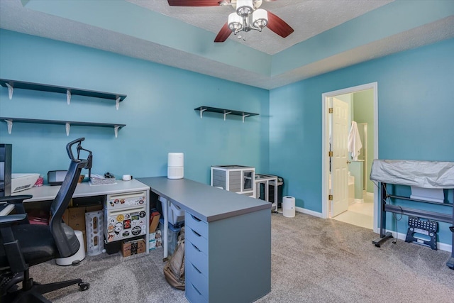 carpeted office space with a textured ceiling and ceiling fan