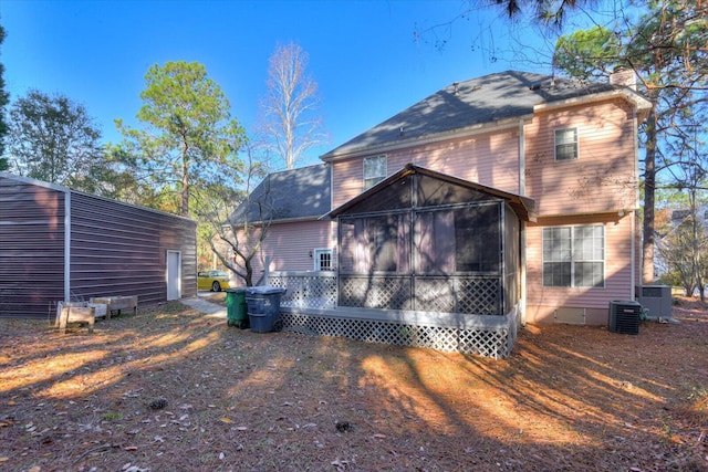 rear view of property featuring a sunroom and cooling unit