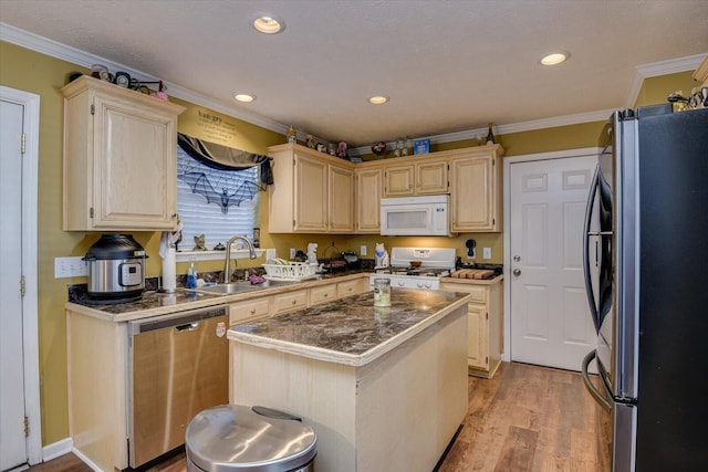 kitchen with a center island, sink, light wood-type flooring, ornamental molding, and appliances with stainless steel finishes