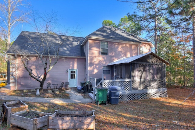 rear view of property featuring a sunroom