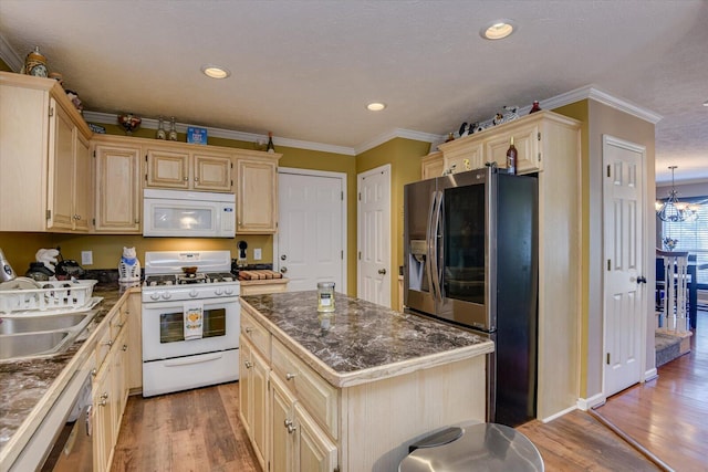 kitchen featuring a center island, stainless steel appliances, a chandelier, hardwood / wood-style flooring, and ornamental molding