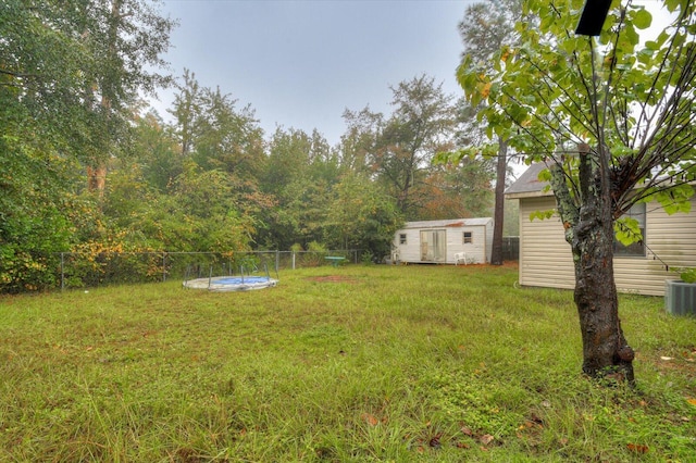 view of yard featuring a storage unit and central air condition unit