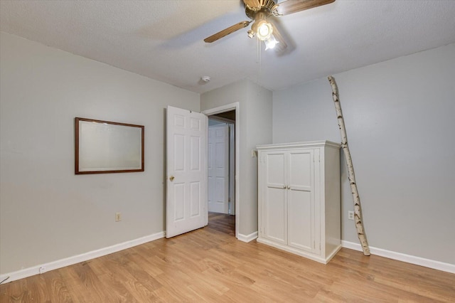 unfurnished bedroom with ceiling fan, light hardwood / wood-style floors, and a textured ceiling