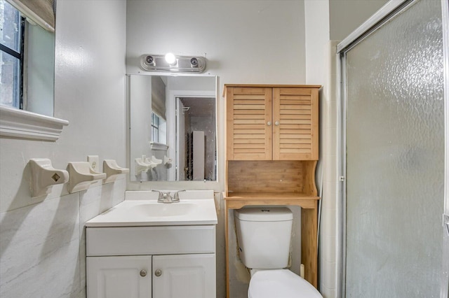 bathroom with vanity, toilet, and a shower with shower door