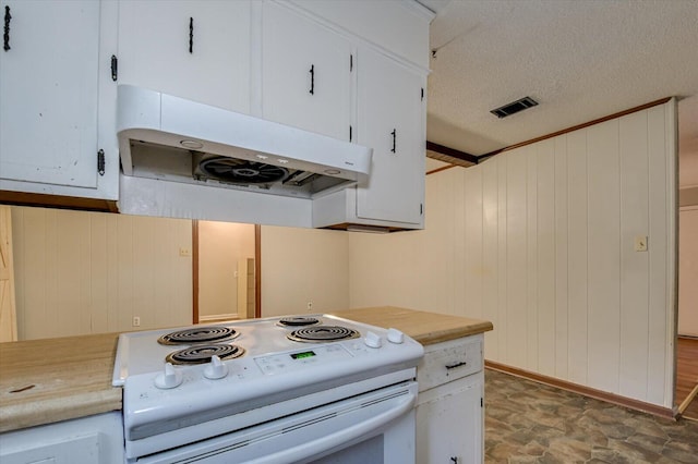 kitchen with white cabinets, a textured ceiling, white electric stove, and wood walls