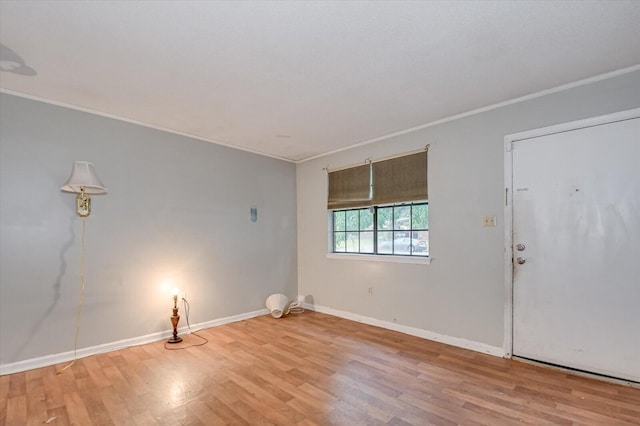 spare room featuring light hardwood / wood-style floors and crown molding