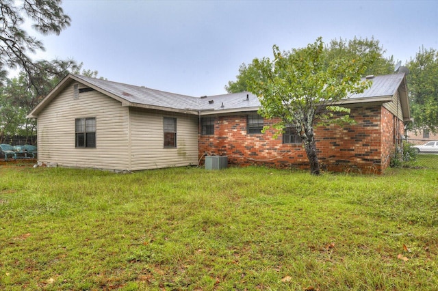 back of property featuring a yard and central air condition unit