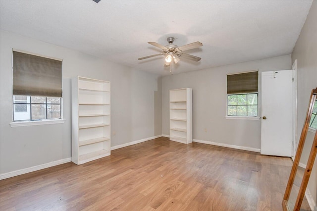 unfurnished bedroom with multiple windows, ceiling fan, and light wood-type flooring