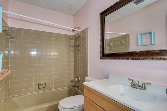 full bathroom with toilet, vanity, and tiled shower / bath