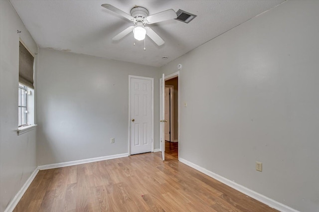 unfurnished room with ceiling fan, light wood-type flooring, and a textured ceiling