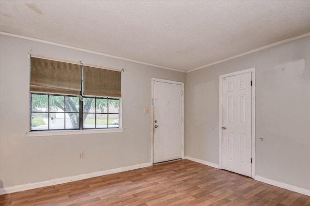 spare room with ornamental molding and light hardwood / wood-style flooring