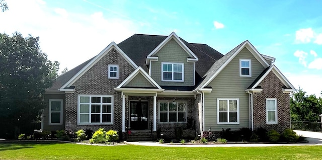 craftsman-style house with brick siding and a front yard