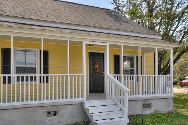 view of exterior entry featuring covered porch