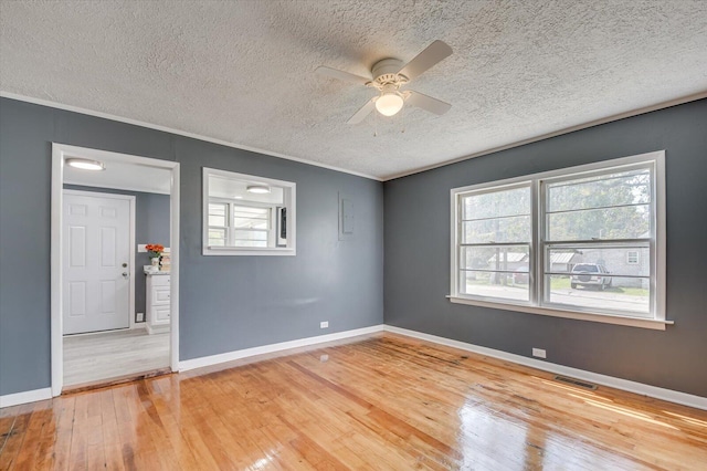 spare room with hardwood / wood-style flooring, ceiling fan, crown molding, and a textured ceiling