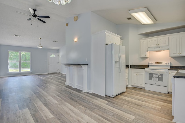 2273 Pund Ave, Augusta, GA 30904 - kitchen featuring white appliances, vaulted ceiling, under cabinet range hood, light wood-style flooring, and dark countertops