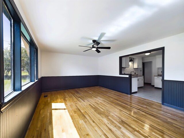 1952 Satcher Blvd, Augusta, GA 30906 - unfurnished living room featuring a wainscoted wall, hardwood / wood-style floors, and a ceiling fan