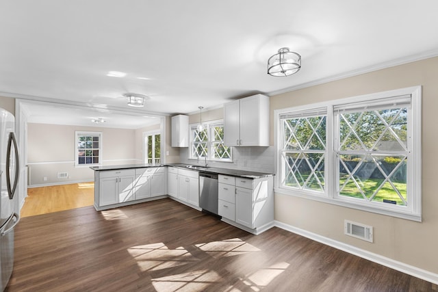 kitchen featuring decorative light fixtures, white cabinetry, kitchen peninsula, and stainless steel appliances