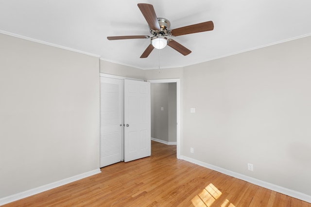 unfurnished bedroom with light wood-type flooring, a closet, ceiling fan, and crown molding