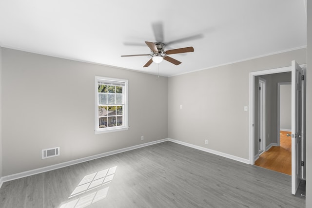 unfurnished room featuring hardwood / wood-style flooring, ceiling fan, and crown molding