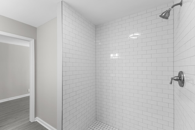 bathroom featuring hardwood / wood-style flooring and tiled shower