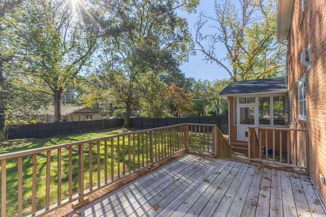 deck with a sunroom and a yard