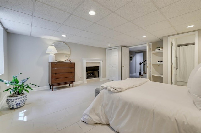 bedroom featuring connected bathroom and a paneled ceiling