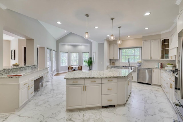 kitchen with a center island, hanging light fixtures, stainless steel dishwasher, backsplash, and vaulted ceiling