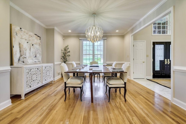 dining room with light hardwood / wood-style flooring, a chandelier, and ornamental molding