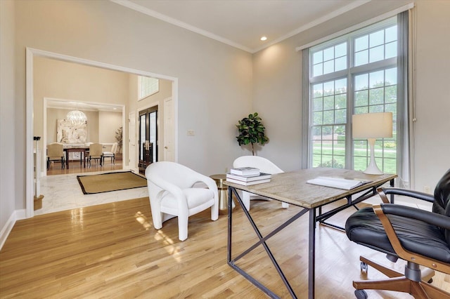 office area with a healthy amount of sunlight, ornamental molding, a chandelier, and light wood-type flooring