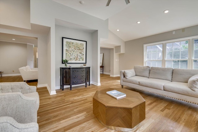 living room featuring ceiling fan, light wood-type flooring, and lofted ceiling