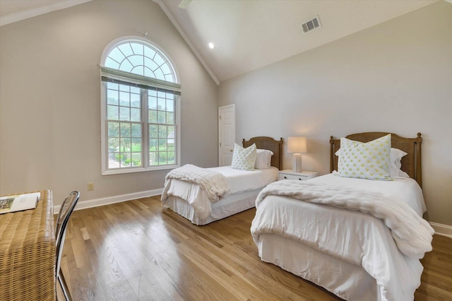 bedroom featuring multiple windows, light hardwood / wood-style flooring, and lofted ceiling