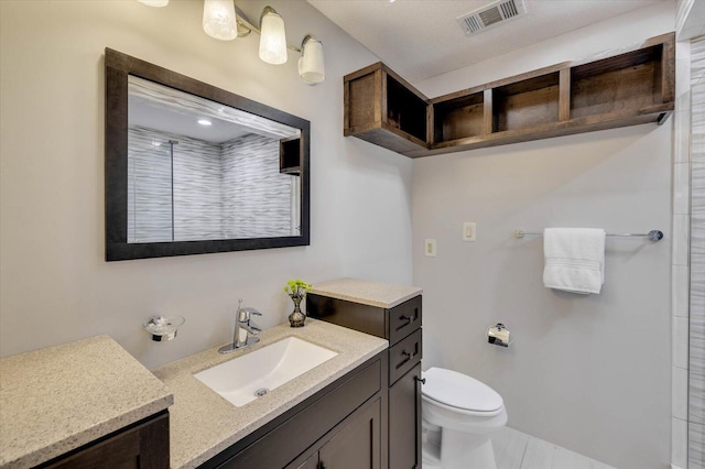 bathroom with a shower, vanity, and toilet