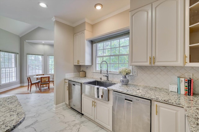 kitchen featuring dishwasher, light stone countertops, and sink