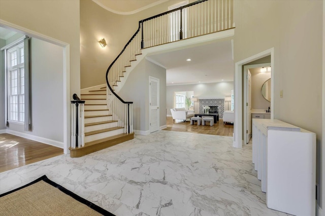 entryway featuring a tiled fireplace and ornamental molding