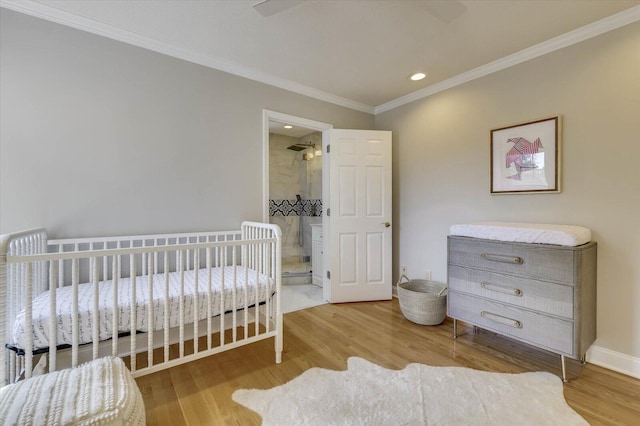 bedroom with ensuite bathroom, hardwood / wood-style flooring, ornamental molding, and ceiling fan