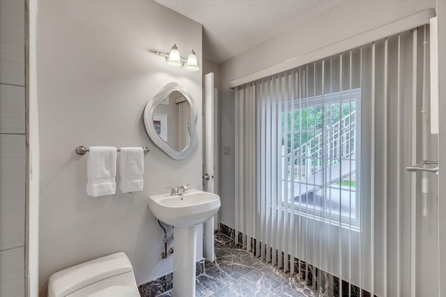 bathroom with sink, toilet, and a textured ceiling