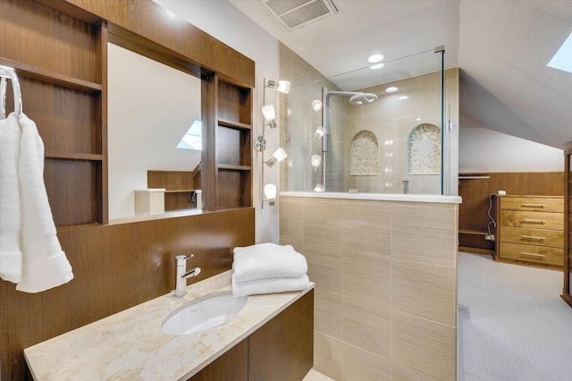 bathroom with tiled shower and vanity