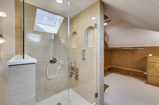 bathroom with a shower with door and lofted ceiling