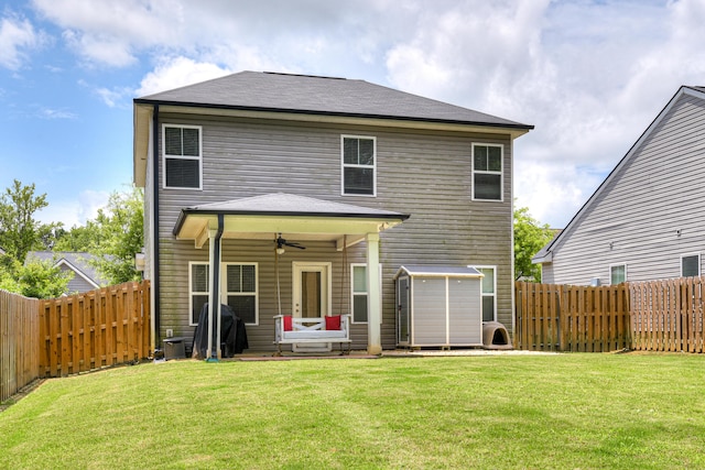 back of property with ceiling fan and a lawn