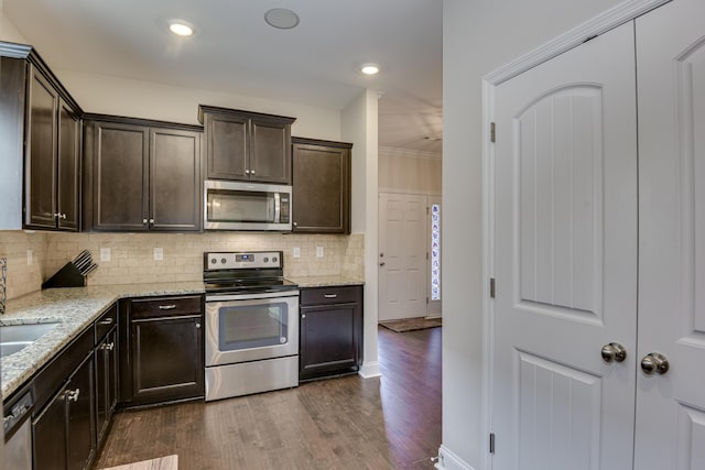 kitchen featuring stainless steel appliances, light stone counters, dark brown cabinetry, and dark hardwood / wood-style flooring