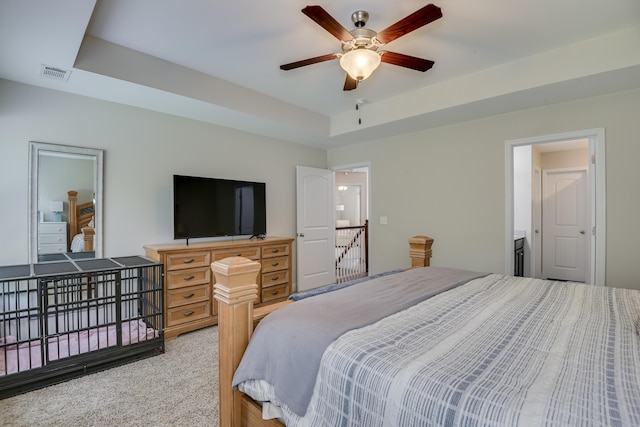 bedroom featuring light colored carpet, ceiling fan, and a tray ceiling