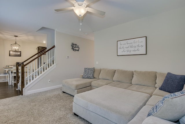 carpeted living room with ceiling fan with notable chandelier