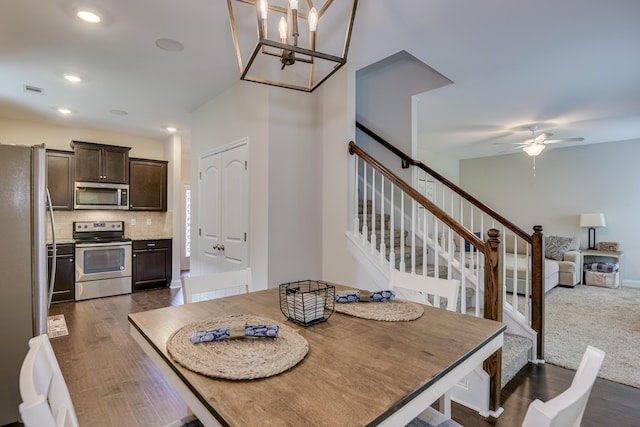 dining space with dark hardwood / wood-style floors and ceiling fan with notable chandelier