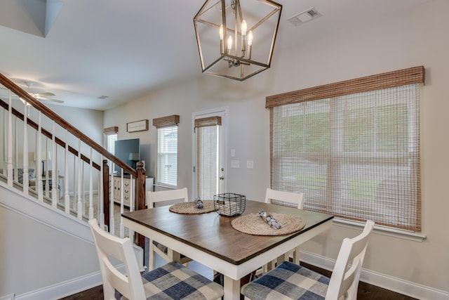 dining area featuring dark hardwood / wood-style floors and ceiling fan with notable chandelier