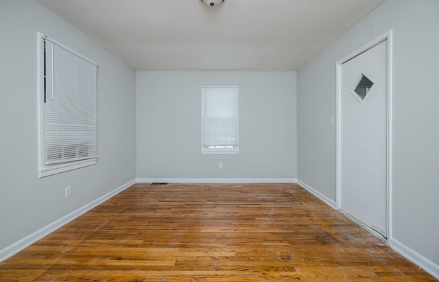 unfurnished room with hardwood / wood-style flooring