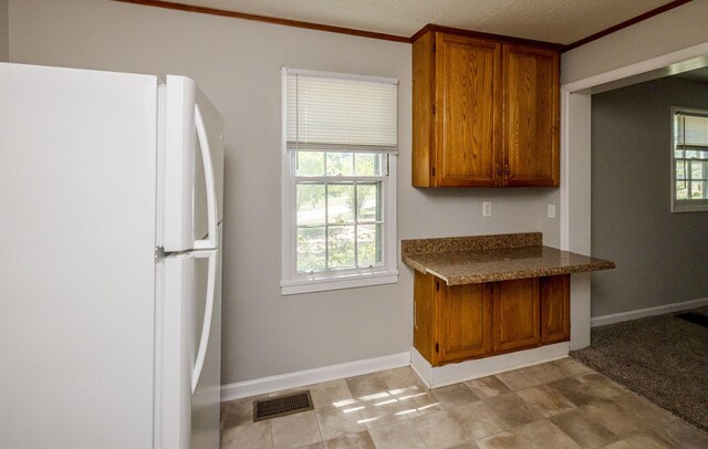 kitchen featuring white refrigerator and crown molding