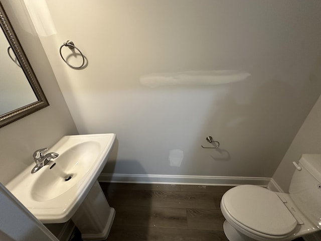 bathroom featuring toilet, sink, and hardwood / wood-style flooring