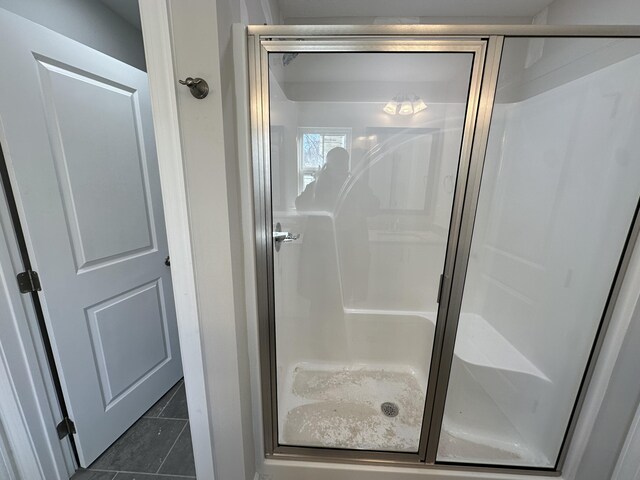 bathroom with walk in shower and tile patterned flooring